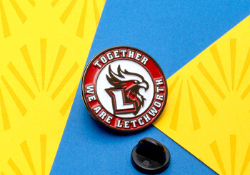 Circular lapel pin featuring a red and white Letchworth eagle logo with a black rubber clutch on a blue and yellow background.
