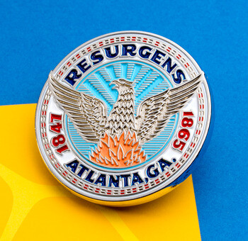Silver challenge coin featuring the Atlanta Resurgens phoenix rising from flames against a light blue sunburst background.